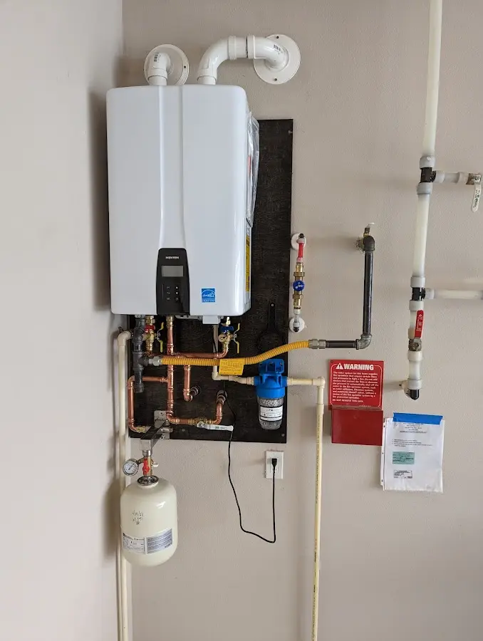 Professional plumber installing copper piping in a Amherst home